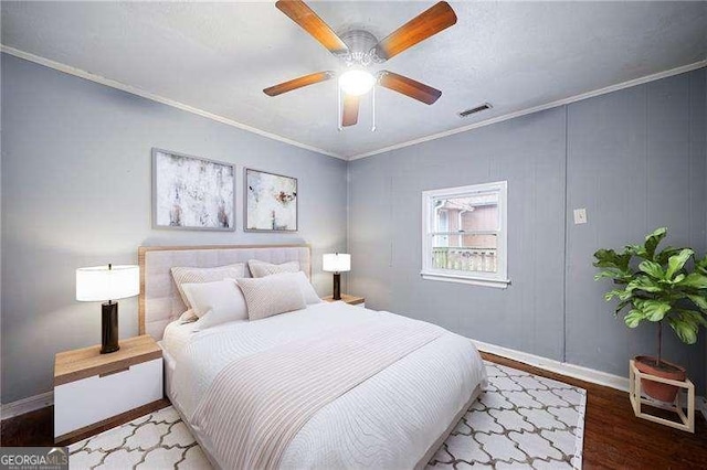 bedroom featuring hardwood / wood-style floors, ceiling fan, and crown molding