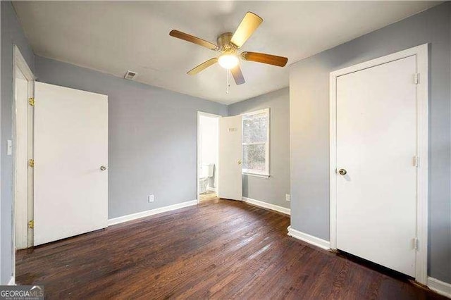 unfurnished bedroom with ceiling fan and dark wood-type flooring