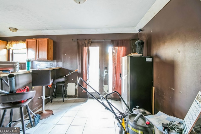 kitchen with stainless steel fridge and light tile patterned floors