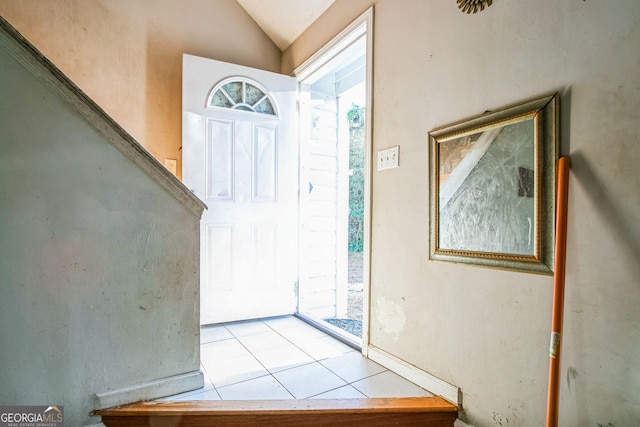 foyer featuring lofted ceiling and light tile patterned flooring