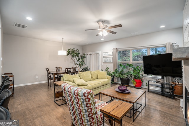 living room with dark hardwood / wood-style floors and ceiling fan