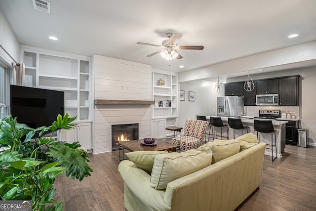 living room with ceiling fan and dark hardwood / wood-style floors