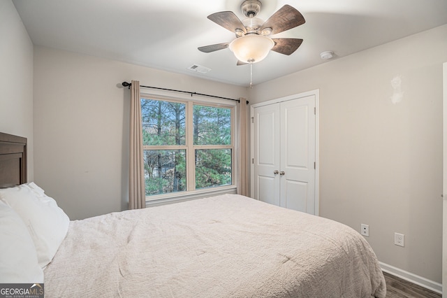 bedroom with ceiling fan, a closet, and wood-type flooring