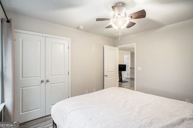 bedroom featuring hardwood / wood-style floors, a closet, and ceiling fan