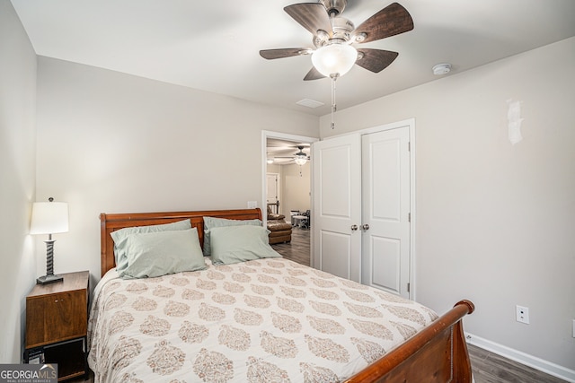 bedroom with dark hardwood / wood-style flooring, a closet, and ceiling fan