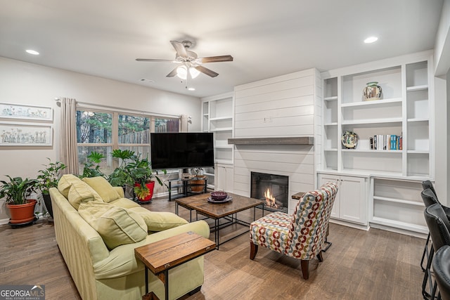 living room featuring ceiling fan and dark wood-type flooring