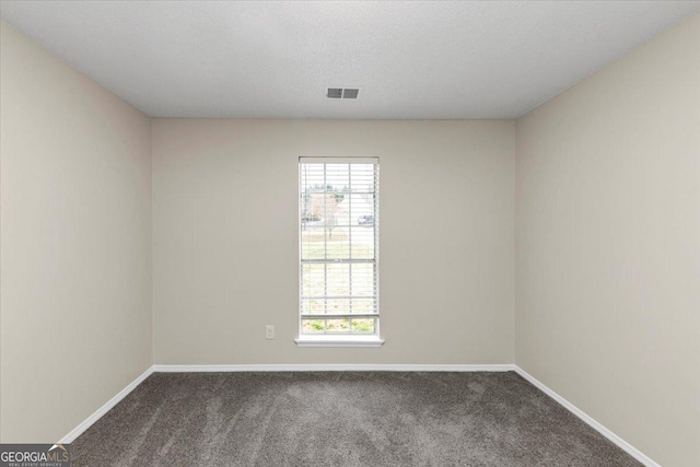 carpeted spare room featuring a textured ceiling