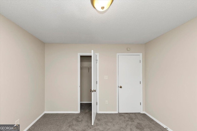 unfurnished bedroom featuring a closet, light colored carpet, and a textured ceiling