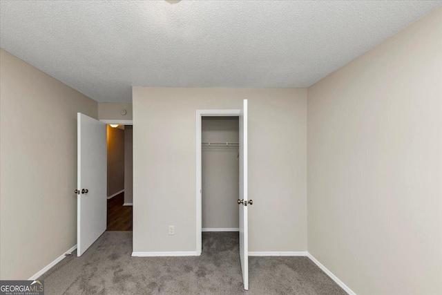 unfurnished bedroom featuring a closet, light colored carpet, and a textured ceiling