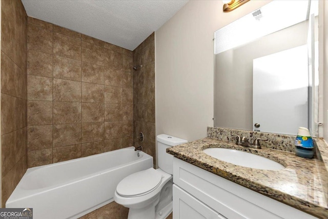 full bathroom featuring vanity, a textured ceiling, toilet, and tiled shower / bath