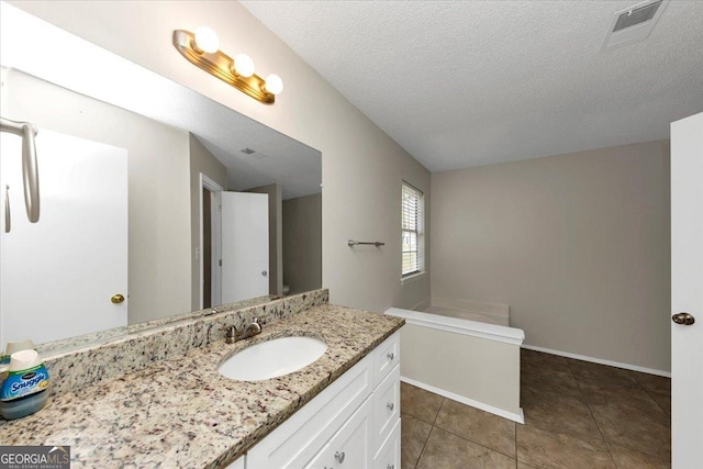 bathroom featuring vanity, a textured ceiling, and tile patterned floors