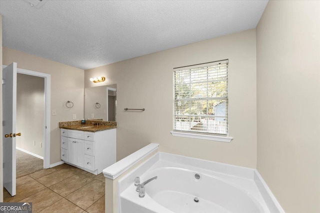 bathroom with vanity, a textured ceiling, tile patterned floors, and a tub