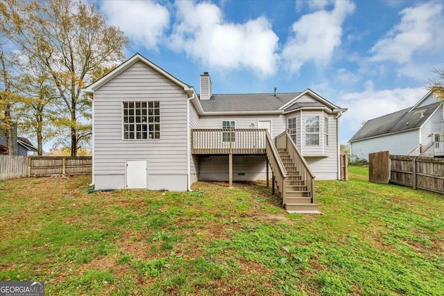 rear view of property with a yard and a deck