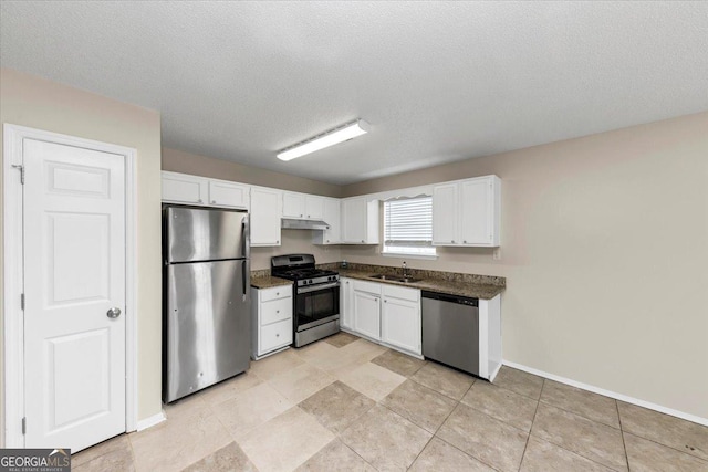 kitchen with a textured ceiling, stainless steel appliances, white cabinetry, and sink