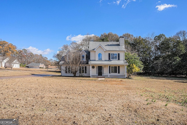 front facade featuring covered porch and a front lawn