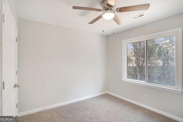 carpeted spare room featuring ceiling fan and a textured ceiling