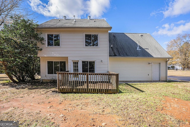 rear view of house with a lawn and a wooden deck