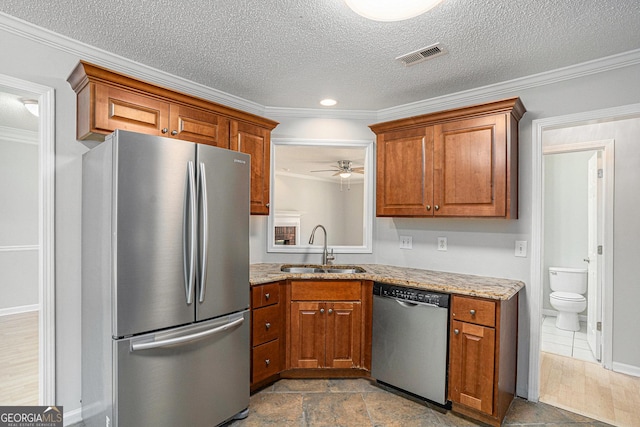 kitchen with a textured ceiling, sink, ornamental molding, and stainless steel appliances