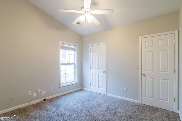 spare room featuring carpet flooring, vaulted ceiling, and ceiling fan