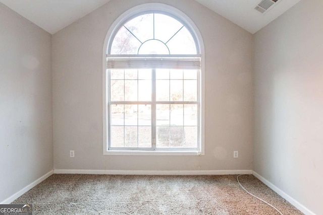 unfurnished room featuring lofted ceiling and carpet floors