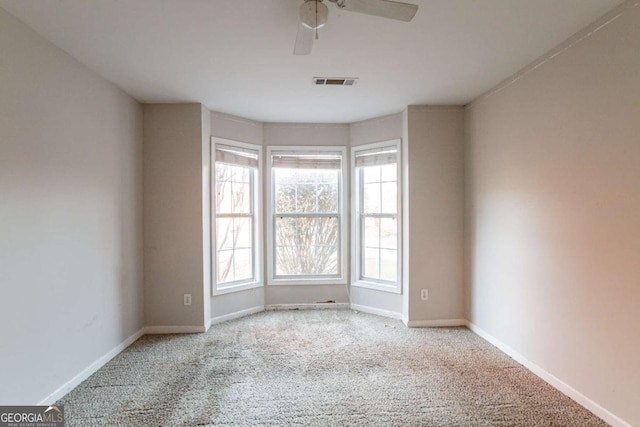 carpeted spare room with ceiling fan