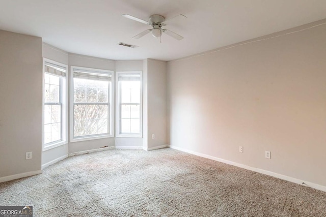 spare room featuring light carpet and ceiling fan