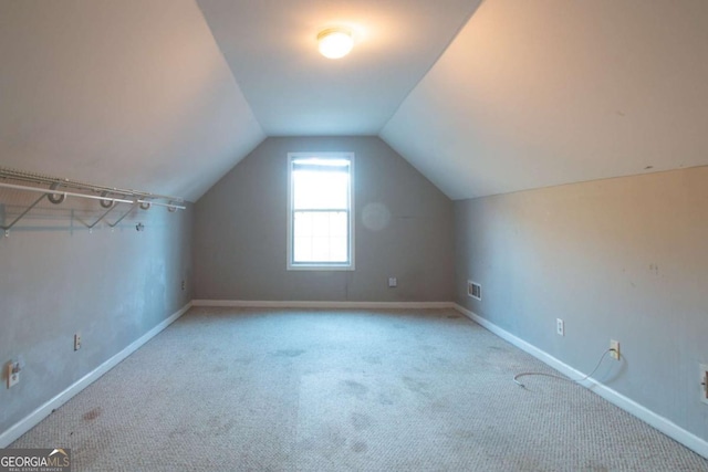 additional living space with light colored carpet and lofted ceiling