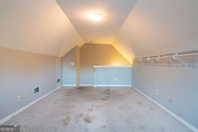 additional living space with light carpet and vaulted ceiling