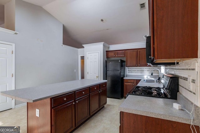 kitchen featuring backsplash, vaulted ceiling, sink, black appliances, and a kitchen island