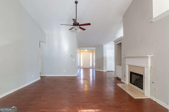 unfurnished living room featuring ceiling fan and dark wood-type flooring