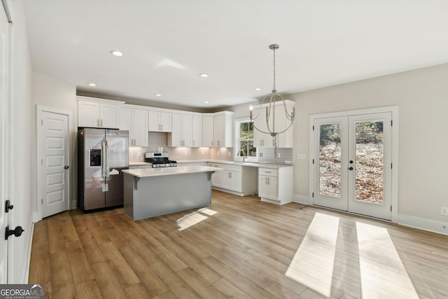 kitchen featuring french doors, light wood-type flooring, stainless steel appliances, and a wealth of natural light