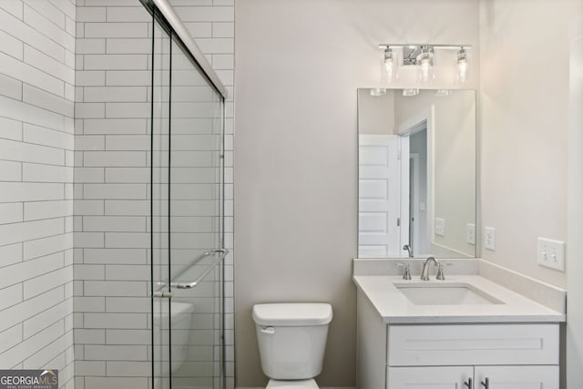 bathroom featuring vanity, toilet, and a shower with shower door