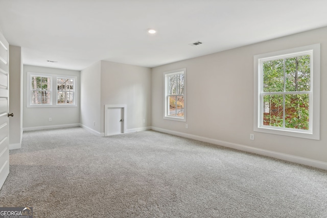 spare room with plenty of natural light and light colored carpet