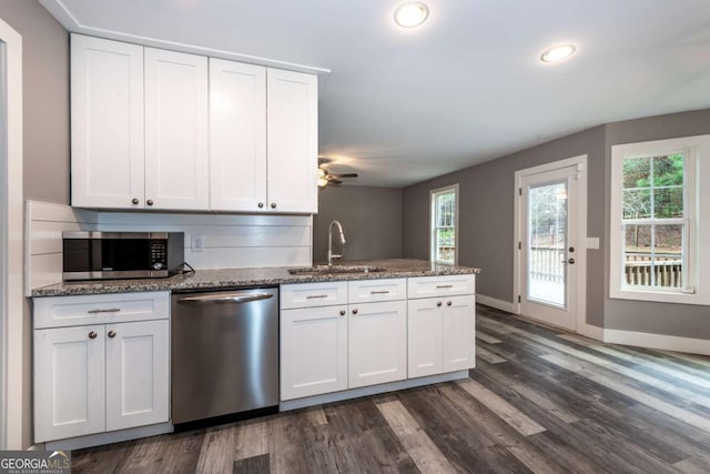 kitchen featuring white cabinets, appliances with stainless steel finishes, and dark wood-type flooring