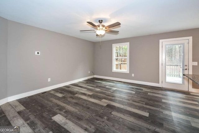 unfurnished room with ceiling fan and dark hardwood / wood-style flooring