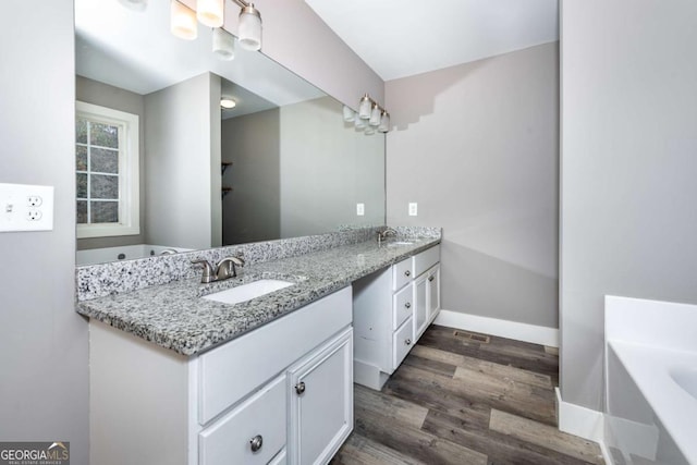 bathroom featuring a bathtub, vanity, and wood-type flooring