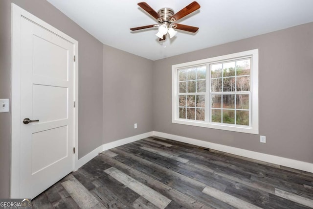 empty room with ceiling fan and dark hardwood / wood-style flooring