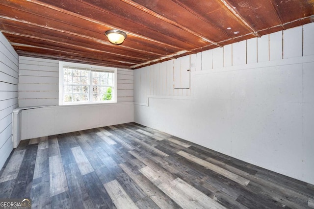 basement featuring dark hardwood / wood-style flooring and wood walls