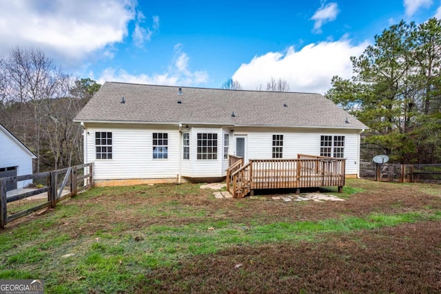 back of property with a yard and a wooden deck