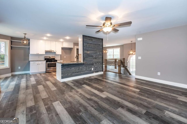 kitchen with stainless steel range, decorative light fixtures, white cabinetry, and a healthy amount of sunlight