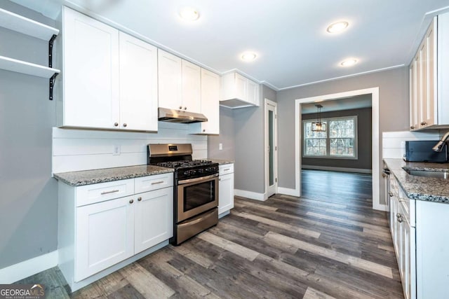 kitchen featuring dark hardwood / wood-style flooring, dark stone counters, gas range, sink, and white cabinets