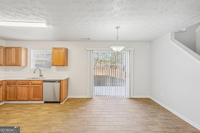 kitchen with light wood-type flooring, a textured ceiling, sink, pendant lighting, and dishwasher