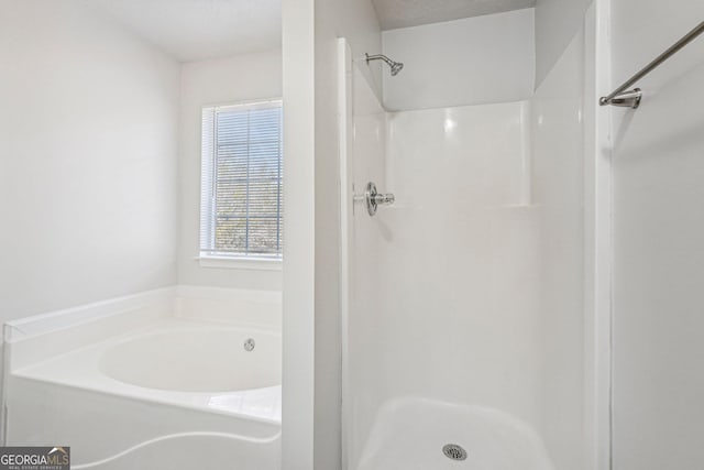 bathroom with separate shower and tub and a textured ceiling