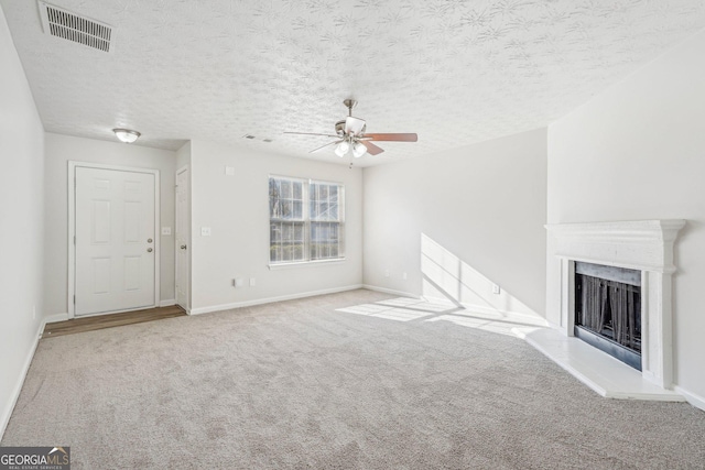 unfurnished living room featuring ceiling fan, light colored carpet, and a textured ceiling