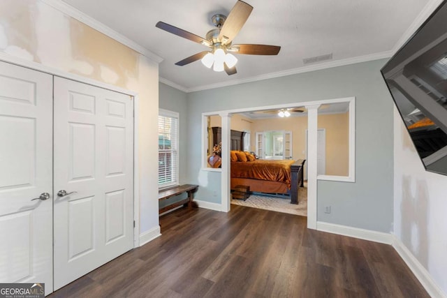 bedroom featuring ornate columns, ornamental molding, ceiling fan, dark wood-type flooring, and a closet