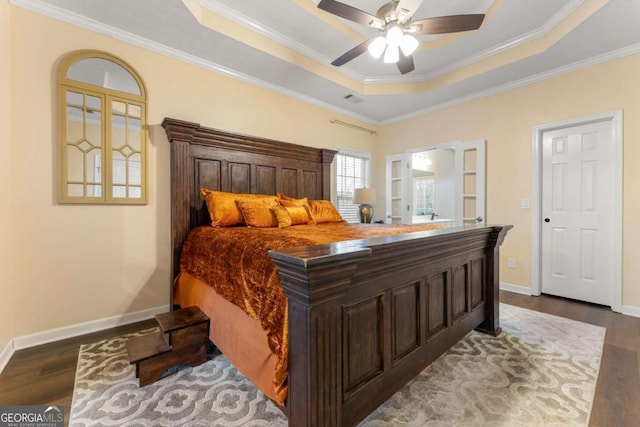 bedroom featuring a tray ceiling, ceiling fan, hardwood / wood-style flooring, and ornamental molding