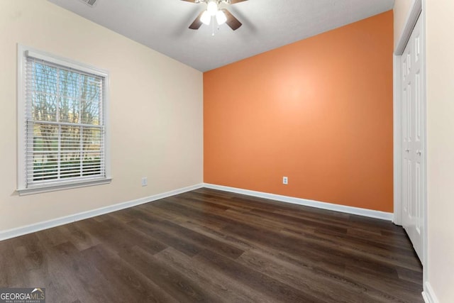 unfurnished bedroom with dark hardwood / wood-style flooring, a closet, and ceiling fan