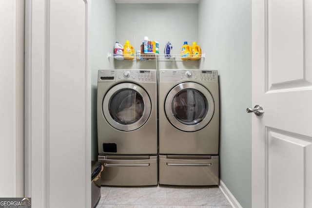 laundry area featuring light tile patterned flooring and washing machine and clothes dryer