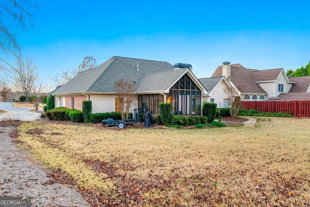 view of front of house with a front yard and a sunroom