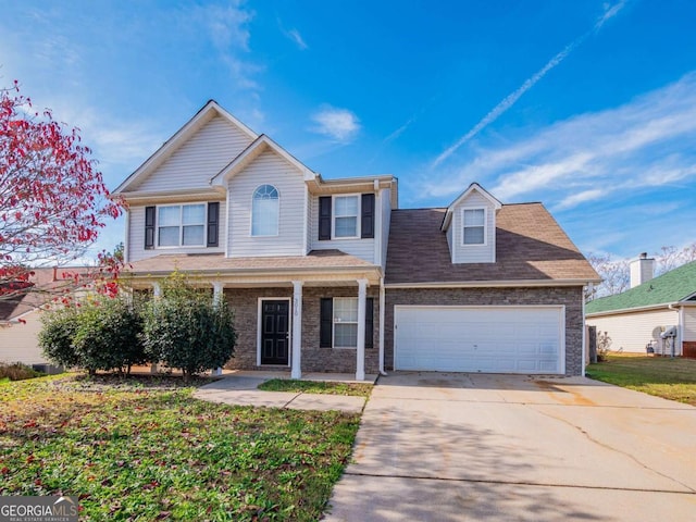 view of front of house featuring a porch, a garage, and a front lawn